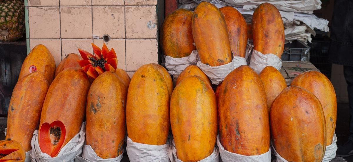 Bright papayas on display at a market stall in Mexico City, showcasing tropical fruit abundance.
